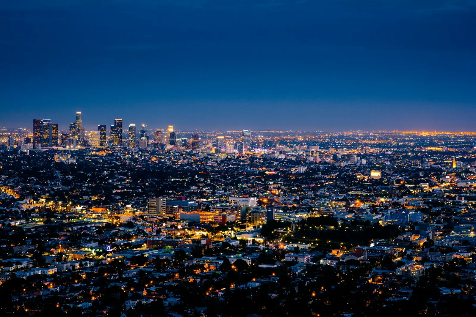 The Los Angeles skyline and city lights at dusk seen from the hills